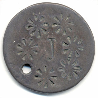 A bronze halfpenny (?) coin which has been smoothed on both sides in order to produce a love token; it has been pierced towards its edge to allow suspension; one side has been engraved with the letter J surrounded by stamped star-like circles; the other side is blank apart from an incomplete stamped circle similar to those on the reverse.