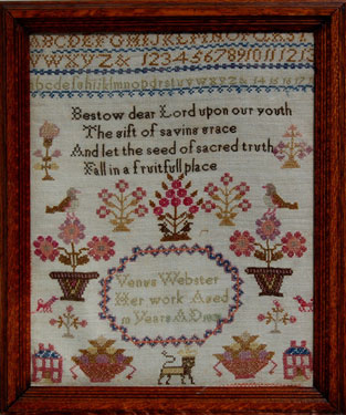 A framed sampler signed Venus Webster, 1831. Alphabet and numbers, religeous text, flowers birds, 2 houses. 