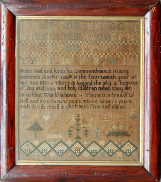 A framed sampler signed by Mary Oakes 1813. Alphabet and numbers, religious verse and birds.