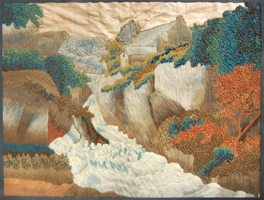 A framed woolwork embroidery in long stitch. Embroidered by Eliza Buckley of Greenfield, Saddleworth, old West Riding of Yorkshire. it depicts a landscape with a cottage and waterfall. 
