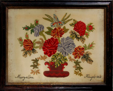 A framed woolwork embroidery signed Maryellen Haigh 1868; depicts flowers in a vase.