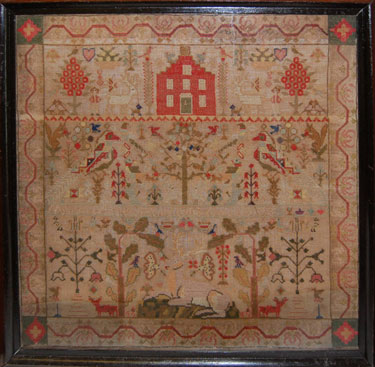A framed sampler signed Mary Teasdale 1863. Elaborate design including stag, deer, trees, flowers, butterfly, birds and squirrels.