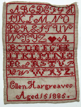 An unframed sampler signed Ellen Hargreaves, aged 15, 1885, in cross stitch with alphabet, heart and inscription.