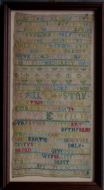 A framed sampler signed E. Mellis, 1800; in cross and eyelet stitch, with alphabet, flowers and inscription.