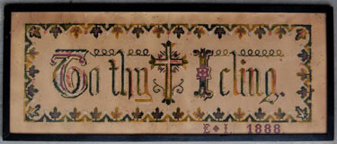 A framed sampler signed E.L., 1888. Simple design with cross in middle and the motto 'To the cross (image) I cling', with leaf border. 