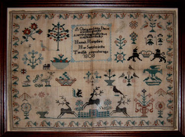 A framed sampler signed Hannah Hampshire, aged 12, 1808. Elaborate design, moral verse, trees, stags, flowers, birds, bordered by honneysuckle.